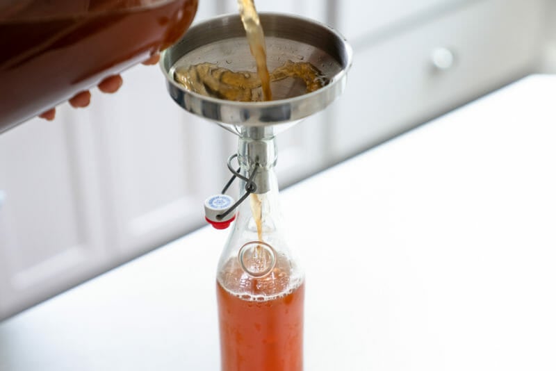 Pouring kombucha into bottle
