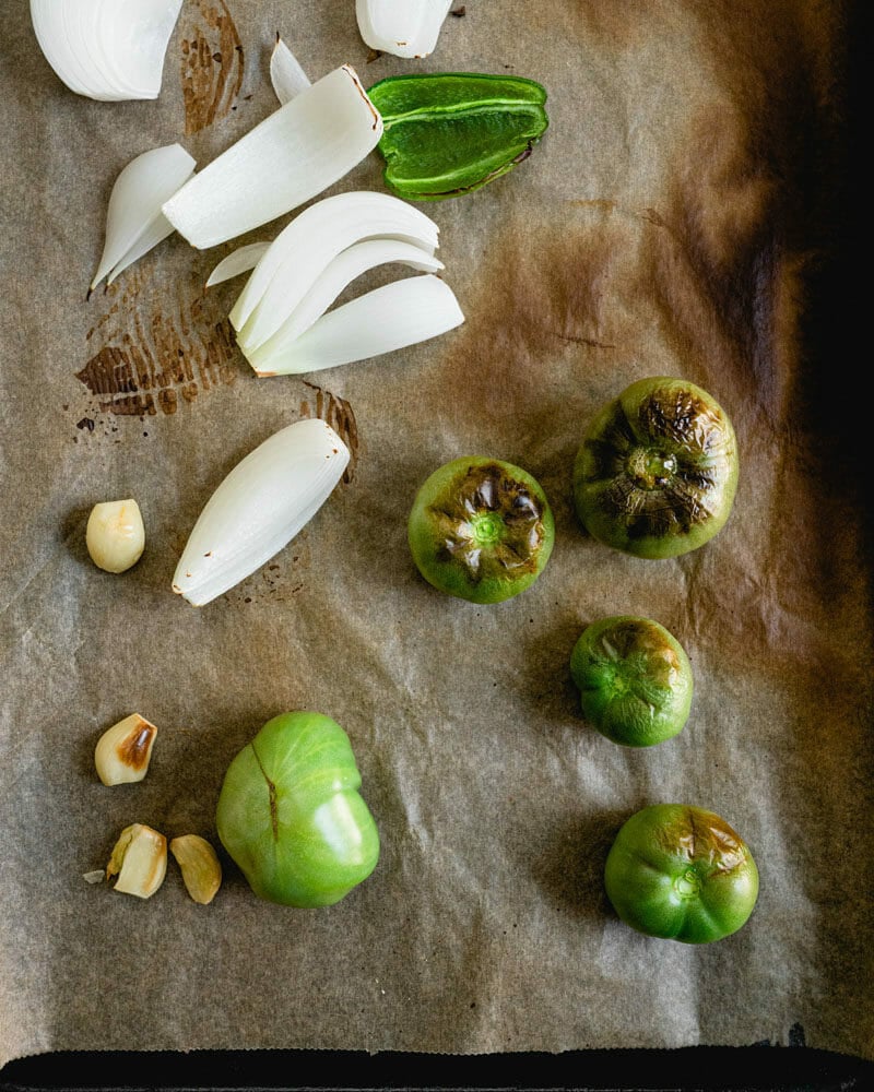 Green tomatoes and onion on baking sheet