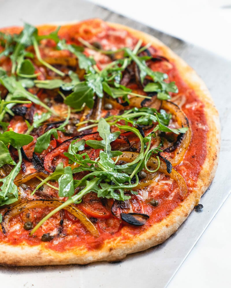 Healthy Pizza with thin crust on pizza peel.