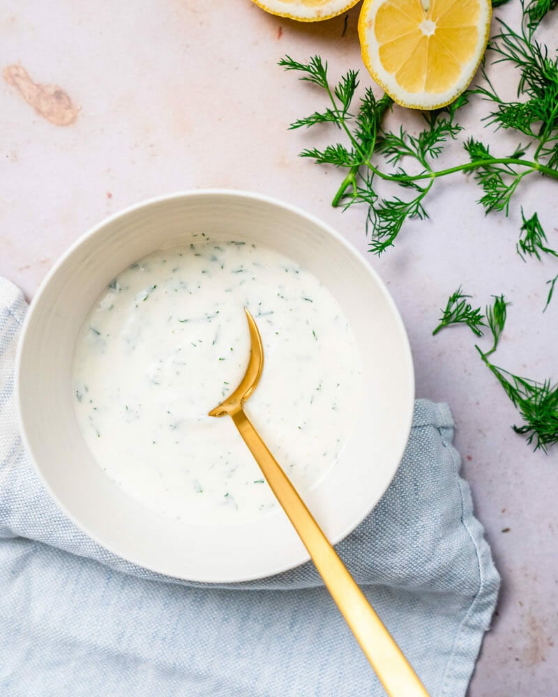 Lemon dill sauce in bowl with spoon.