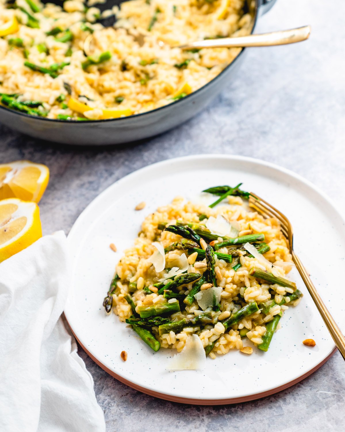 Asparagus risotto on plate with pot in background.