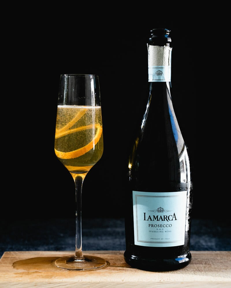 Prosecco cocktails: bubbly cocktail with orange garnish and Prosecco bottle