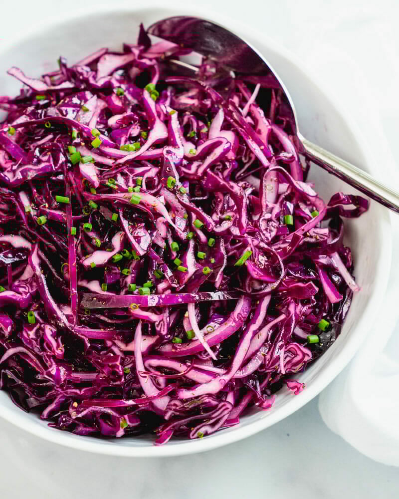 Red cabbage slaw in bowl with spoon