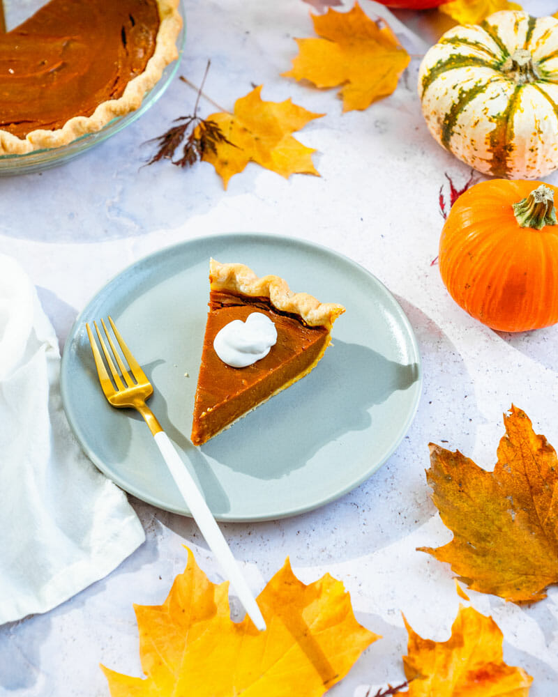 Vegan pumpkin pie with fall leaves on a table