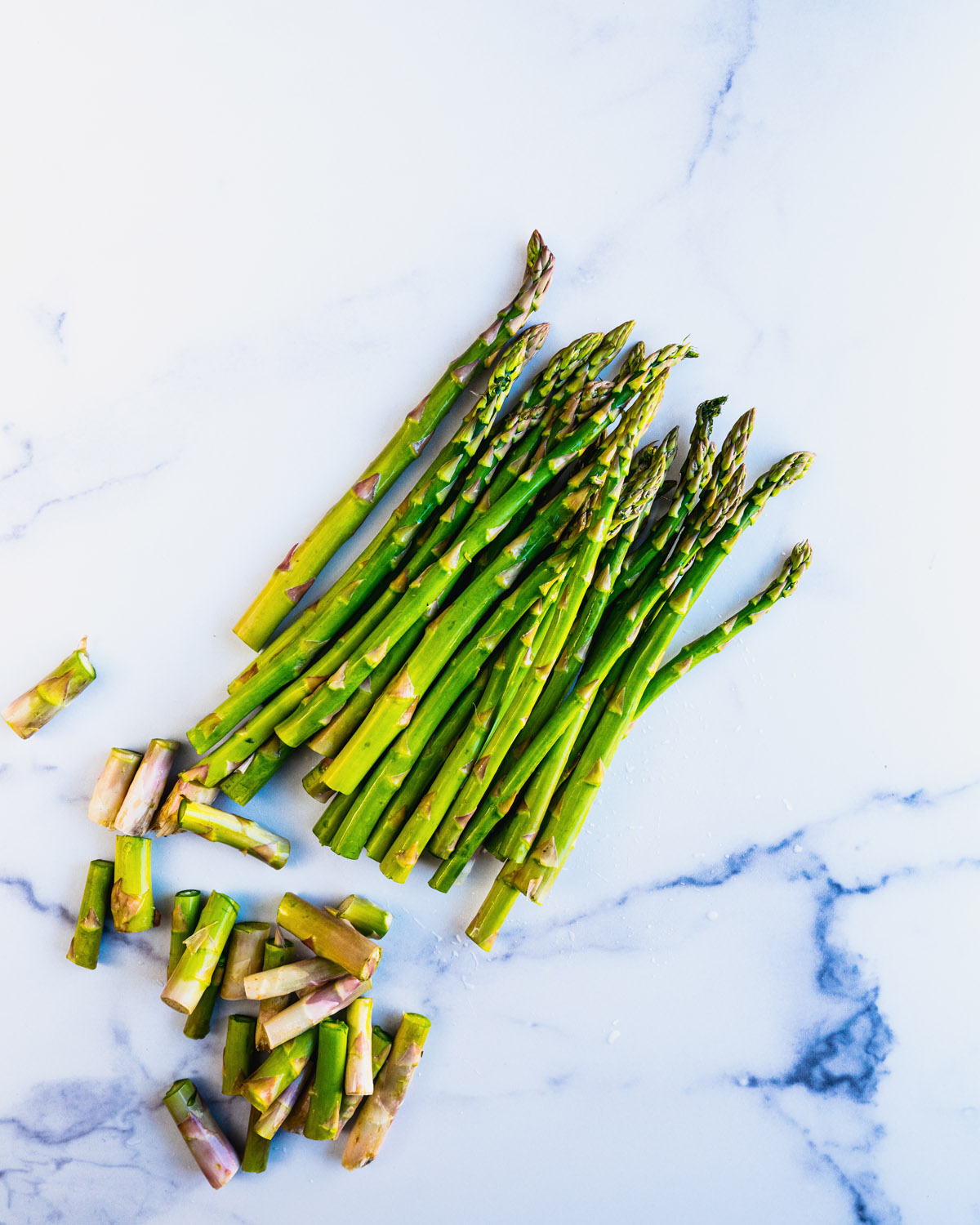 How to trim asparagus: trimmed asparagus on marble.