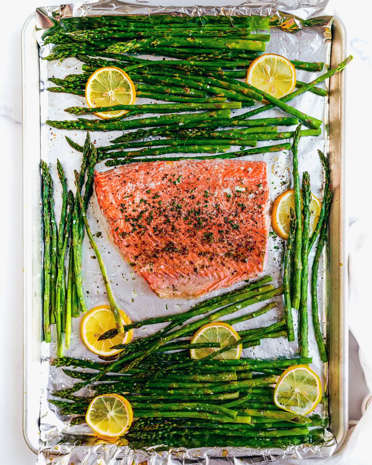 Salmon and asparagus recipe with bunches of asparagus and lemon slices. 