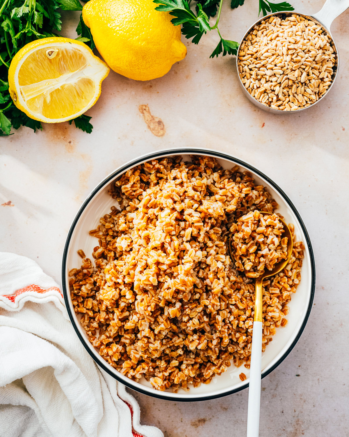 Farro in bowl with lemons and uncooked farro