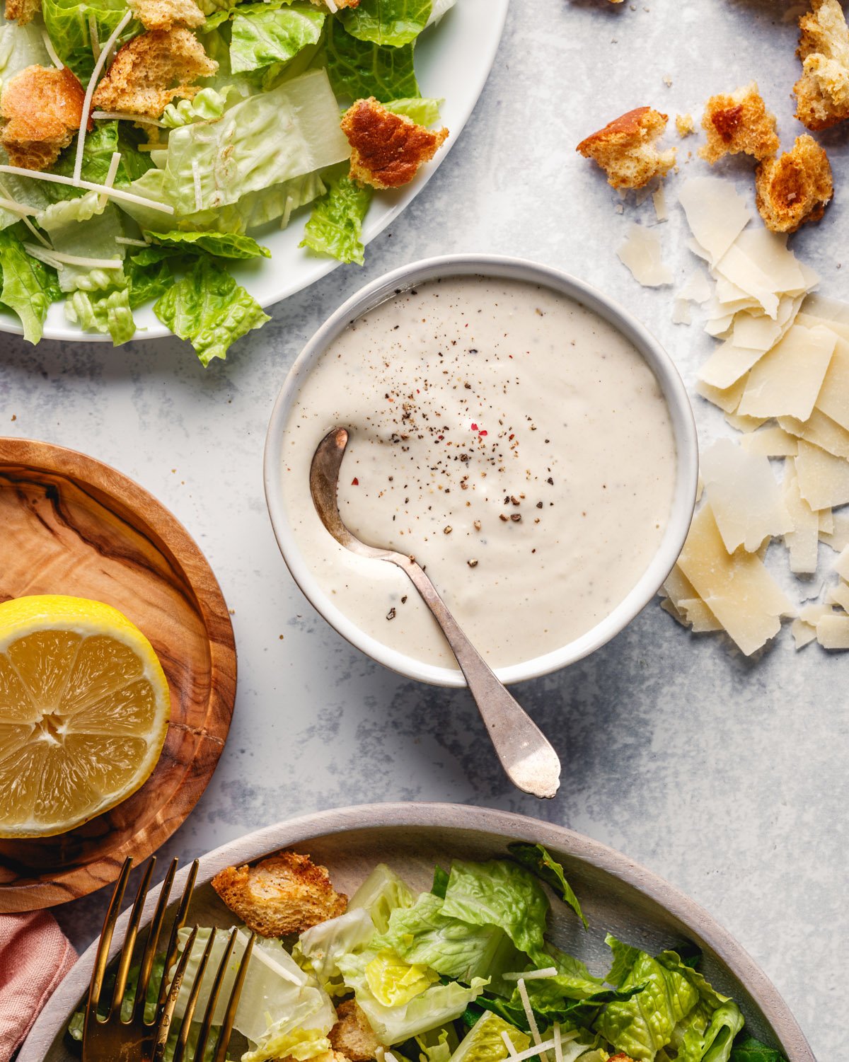 Homemade Caesar salad dressing recipe in bowl with spoon.