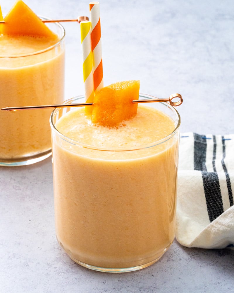 Cantaloupe smoothie with cantaloupe chunk and two straws