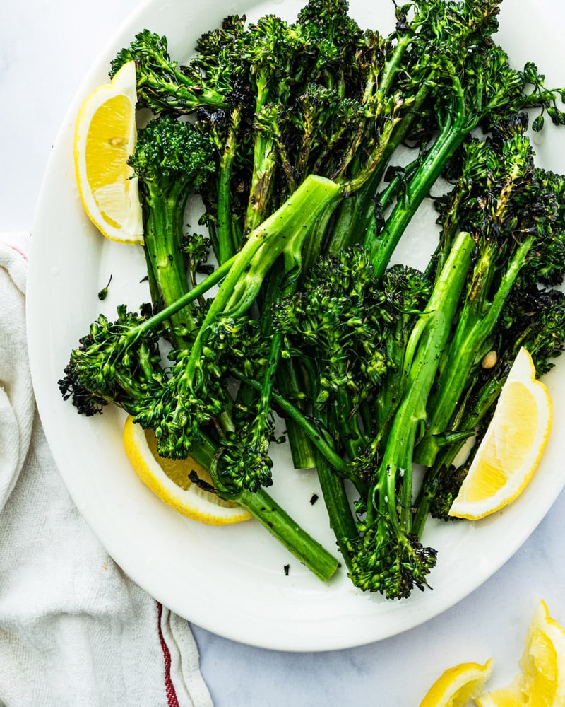 Grilled Broccolini with lemon on platter. 