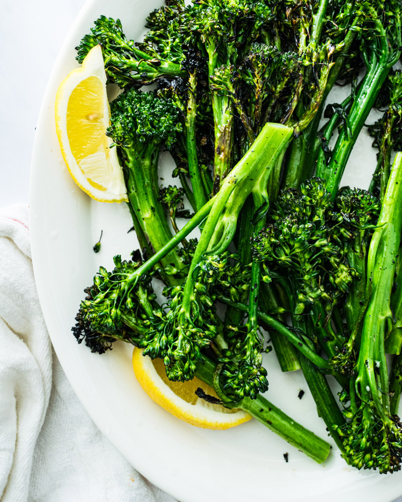 Grilled Broccolini with lemon wedges.