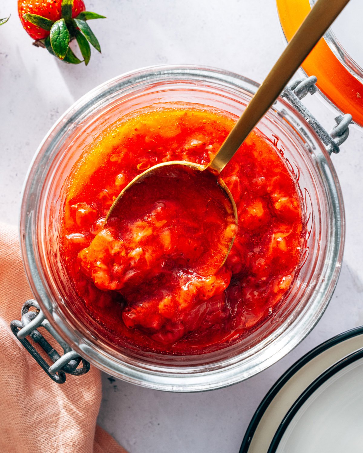 Strawberry Compote in a jar with gold spoon.