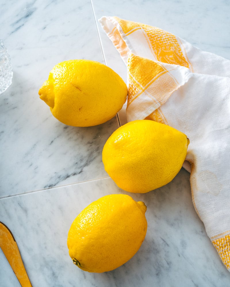 Lemons on marble surface with napkin.