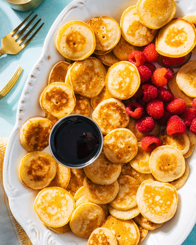 Mini Pancakes on plate with syrup and raspberries