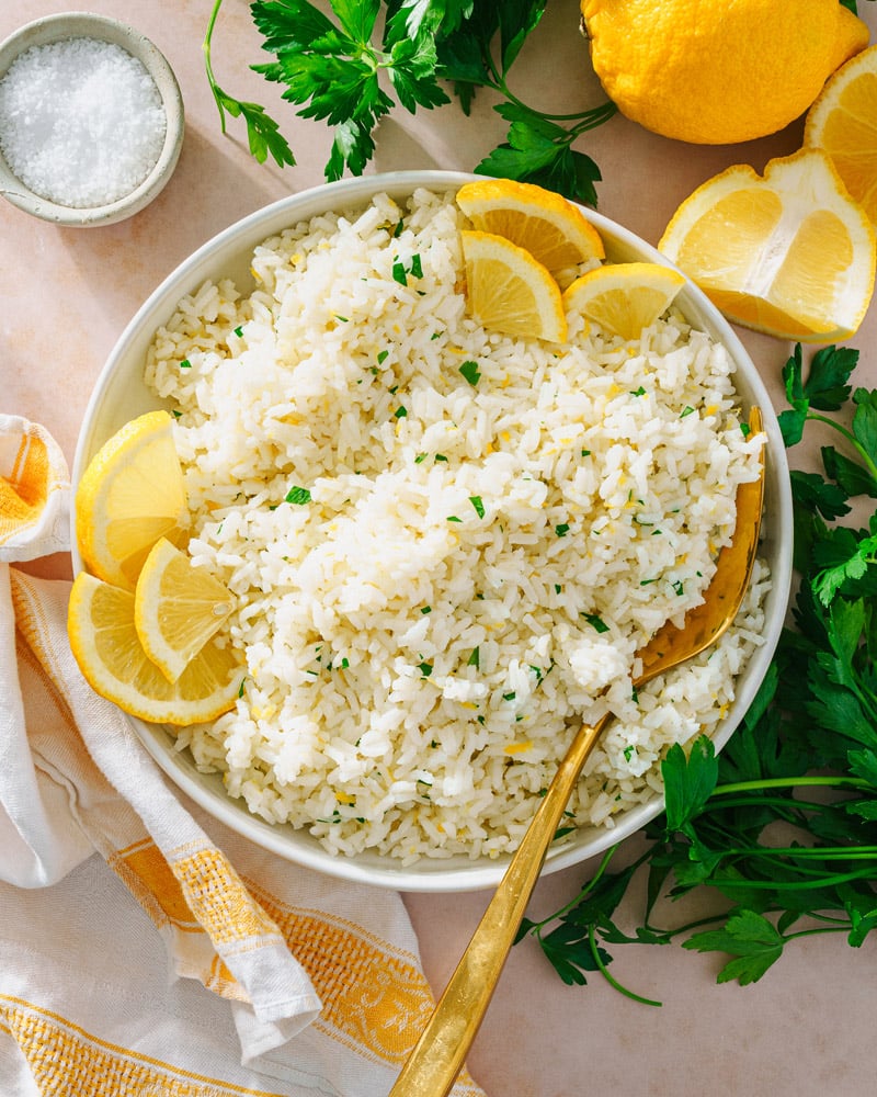 Lemon Rice in serving bowl with spoon and lemon slices. 