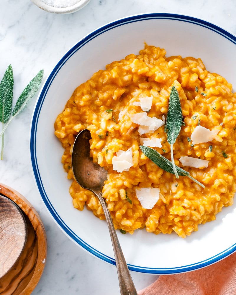Pumpkin Risotto in bowl with spoon and sage garnish