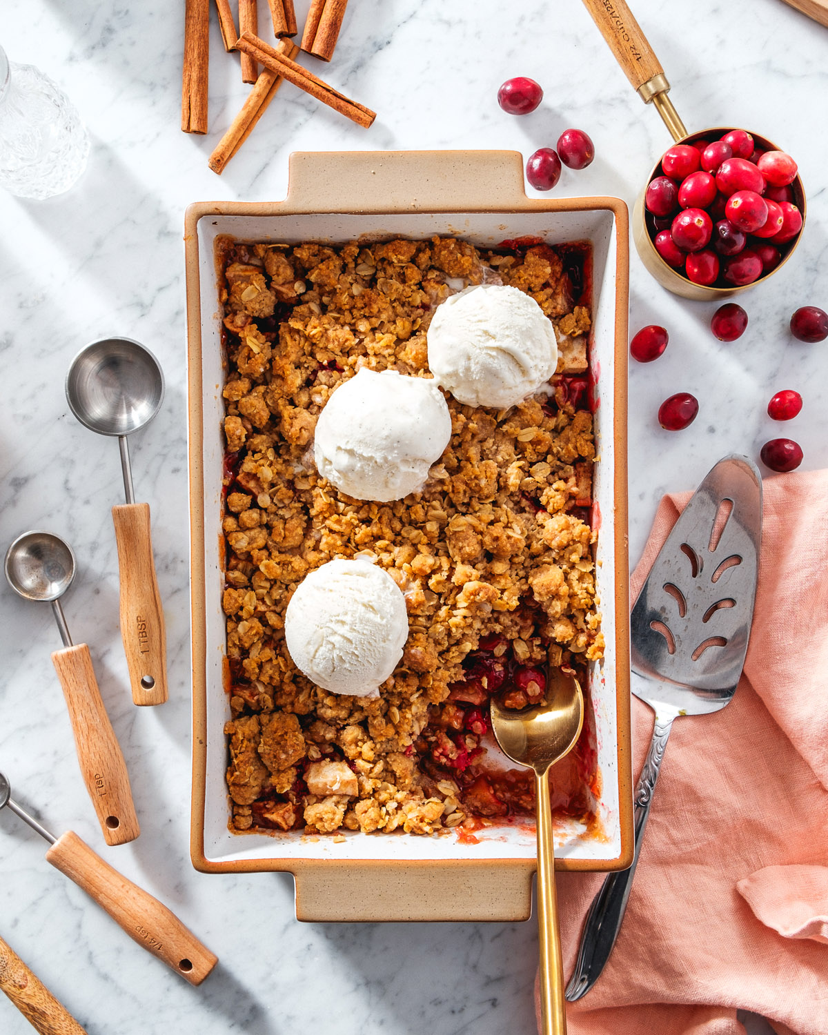 Apple Cranberry Crisp recipe with measuring cup of cranberries