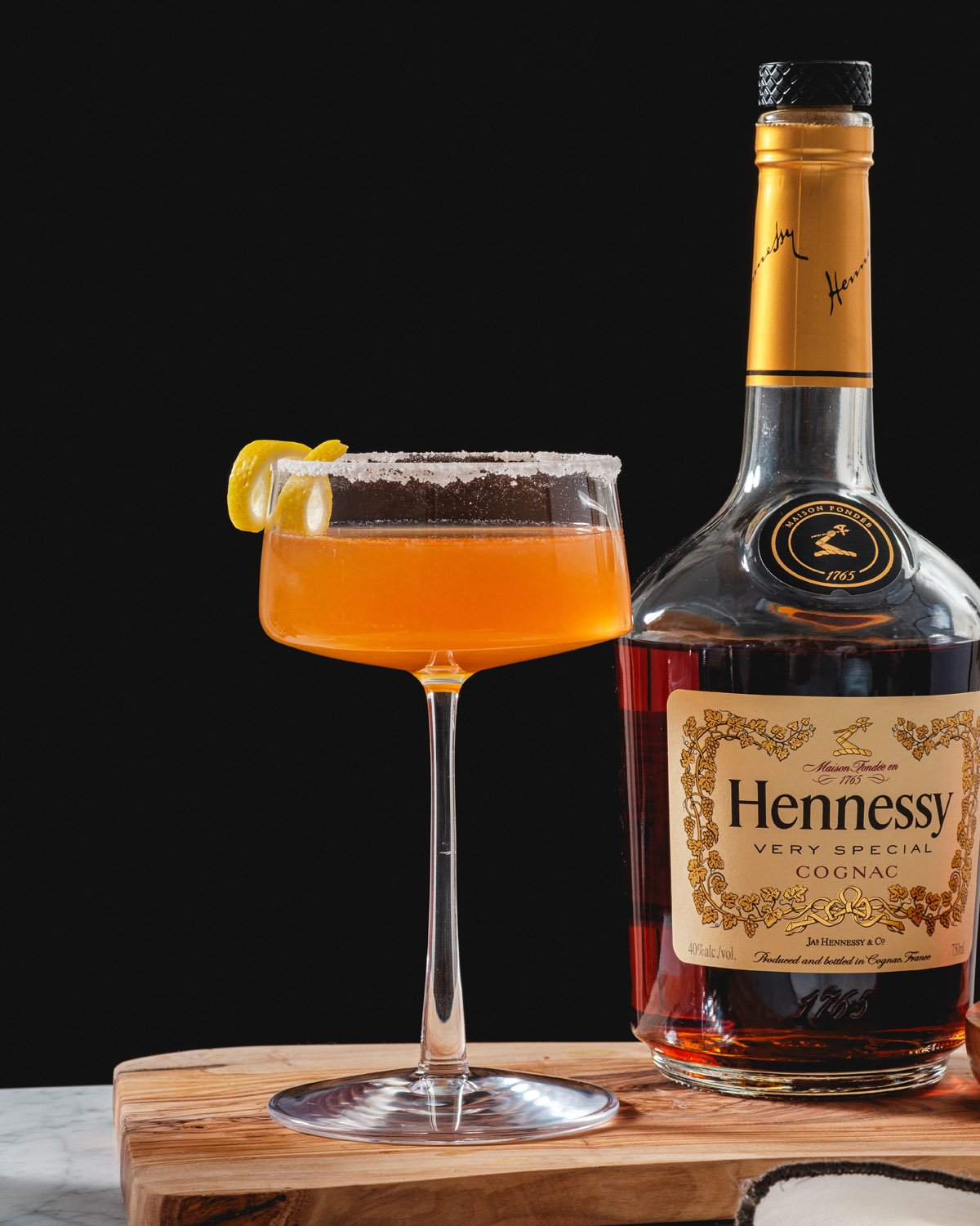 Hennessy Sidecar recipe in cocktail glass with lemon twist and sugar rim