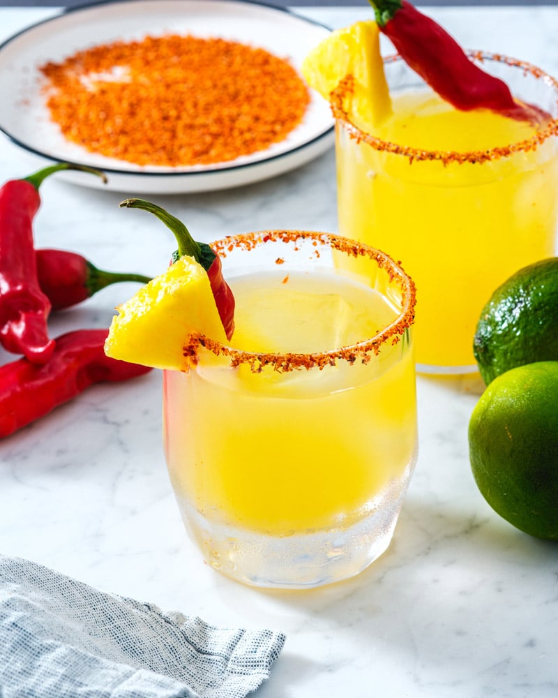 Spicy Pineapple Margarita in glass with spicy pepper and tajin rim