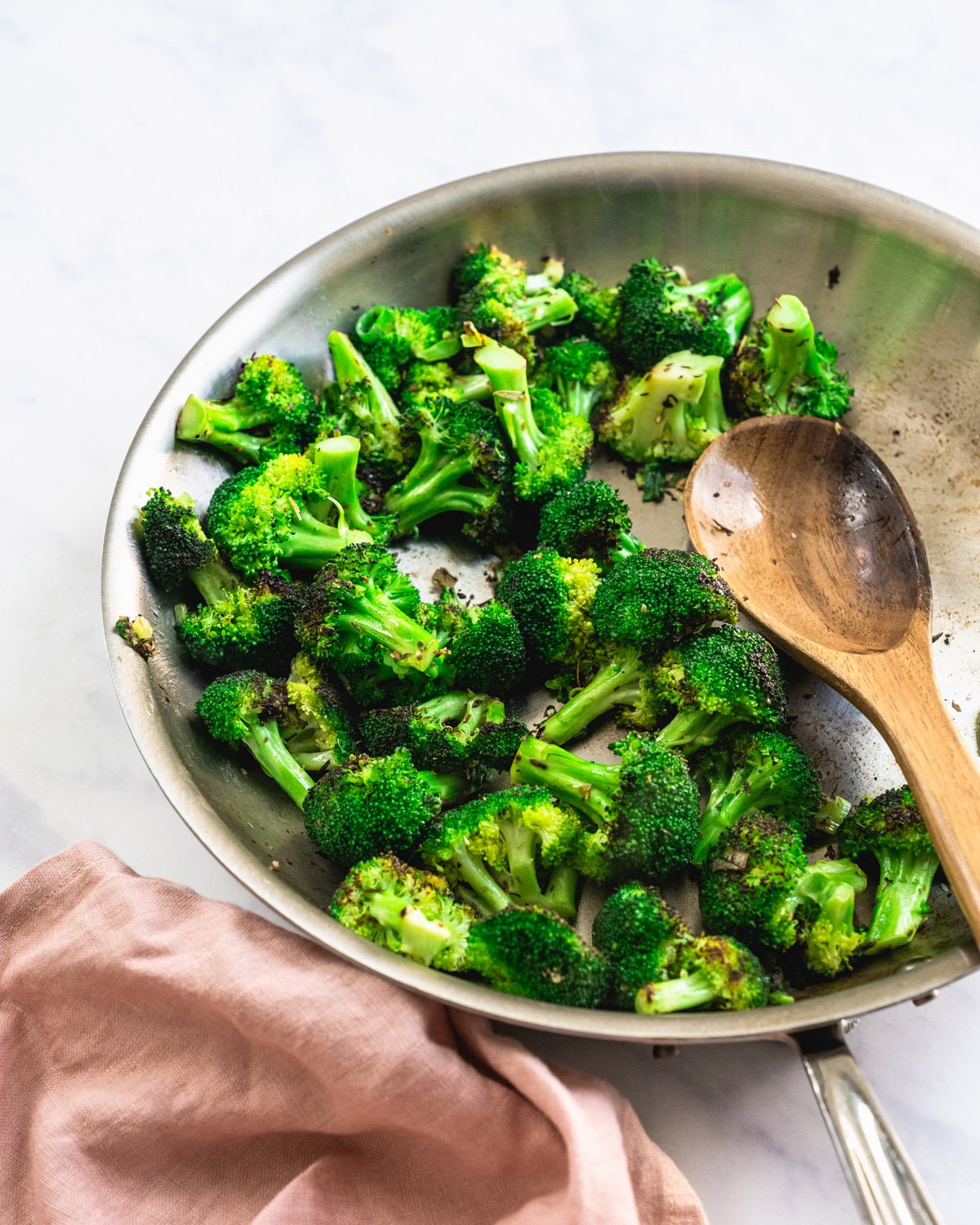 Sauteed Broccoli in pan with spoon.