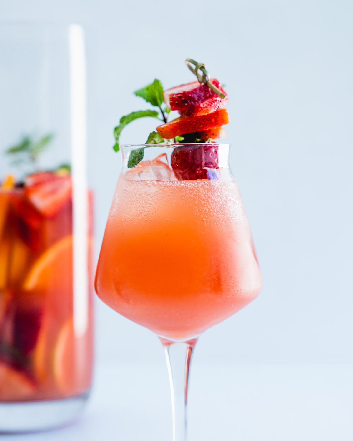 Spring Cocktail in glass: strawberry sangria with strawberry garnish and mint.