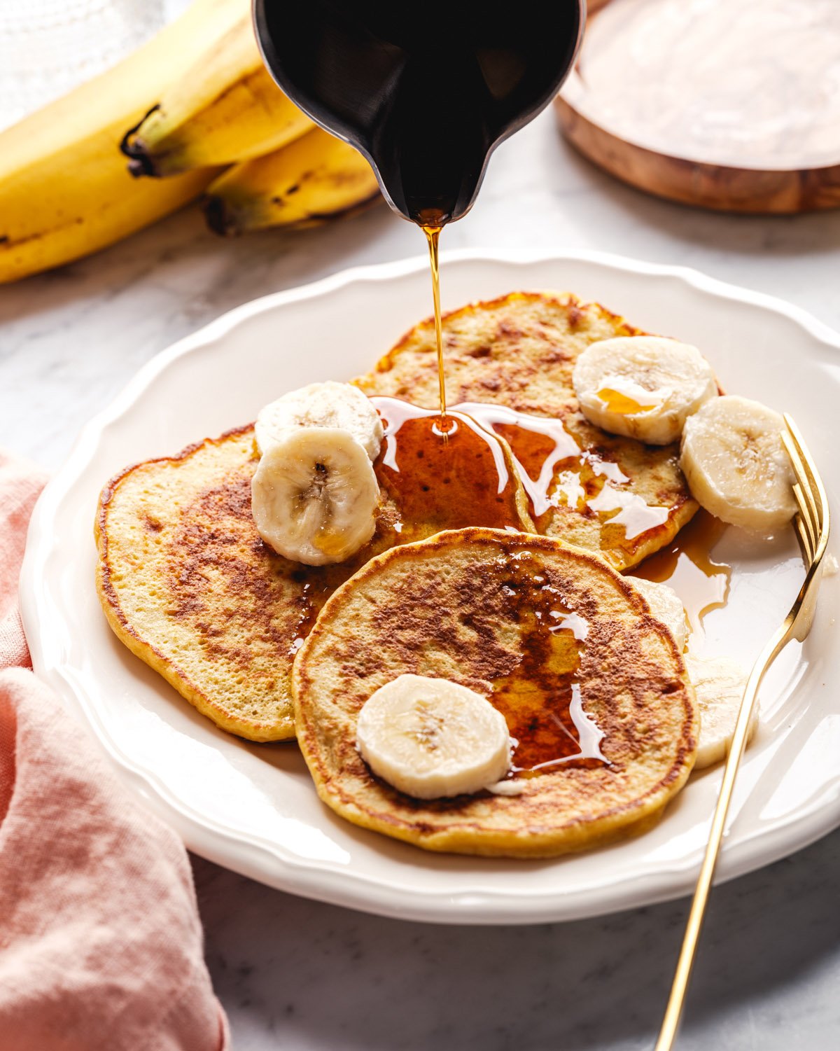 3 ingredient banana pancakes with maple syrup pouring on top.