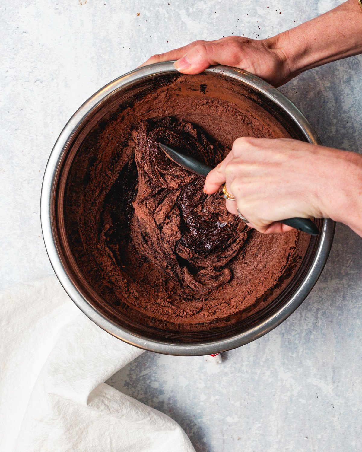 Brownie batter ingredients in a bowl with whisk.