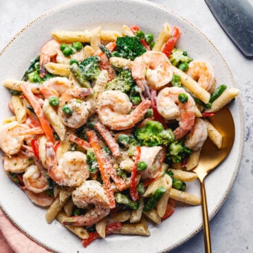 Shrimp Primavera in bowl with colorful vegetables and creamy sauce.