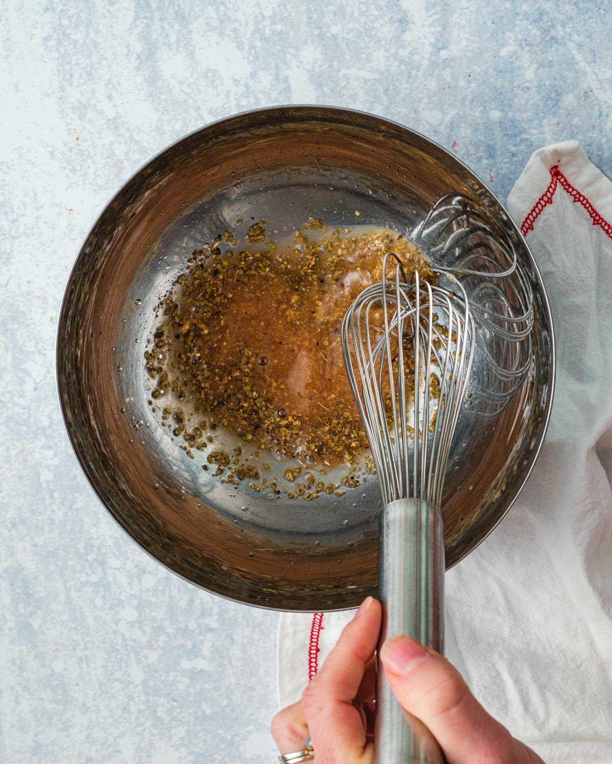 Greek salad dressing Step 1: whisk the red wine vinegar, lemon, Dijon, and herbs.