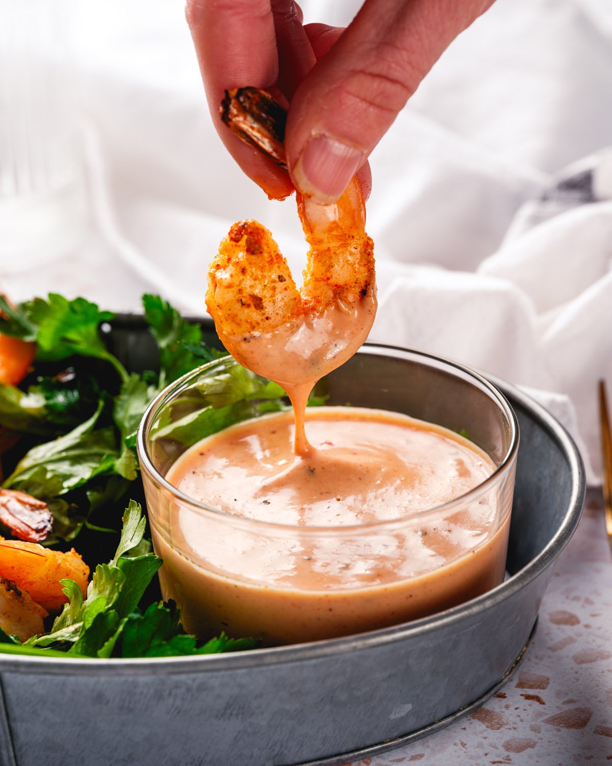 Grilled shrimp dipping into comeback sauce