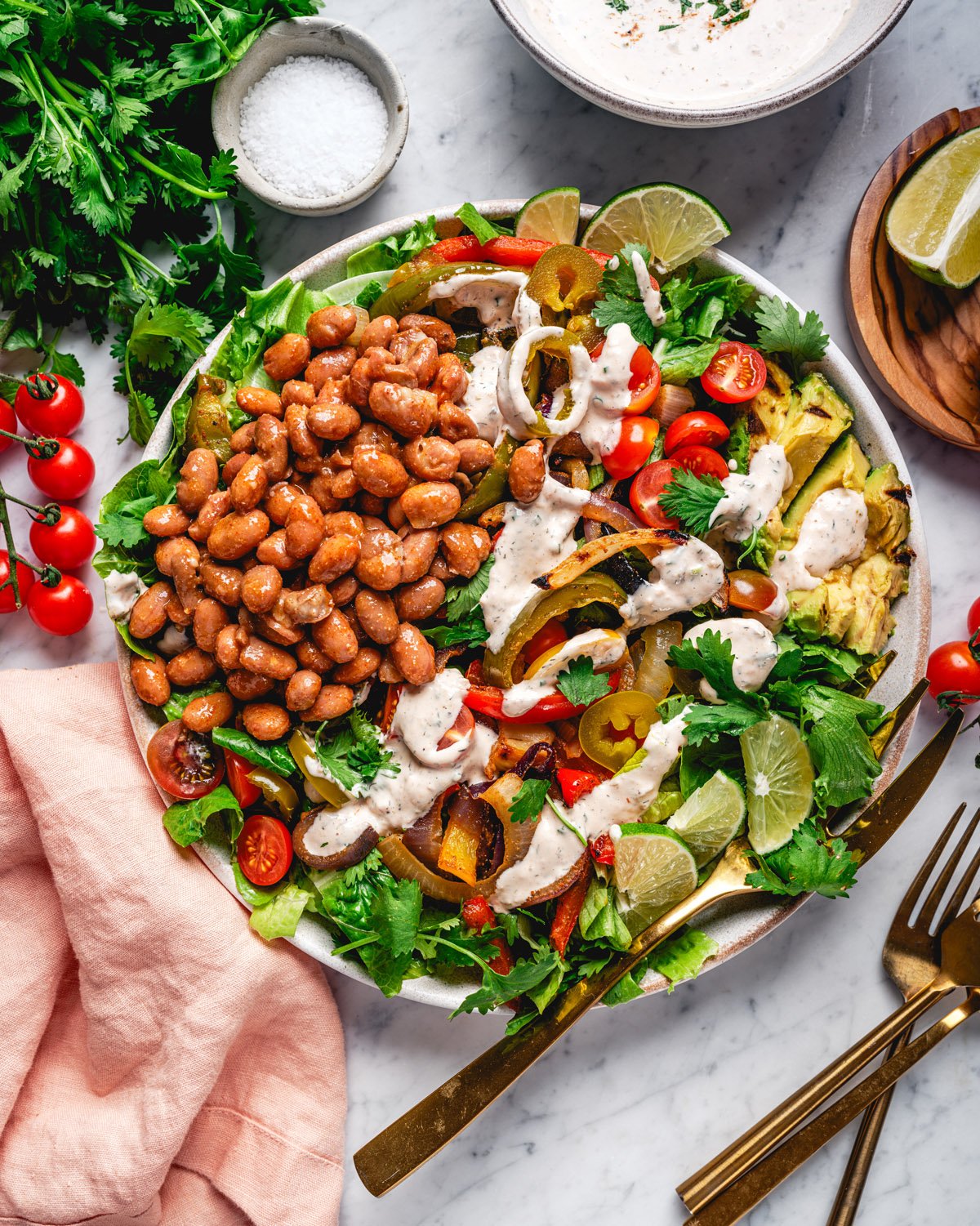 Fajita Salad in bowl drizzled with salsa ranch dressing. 