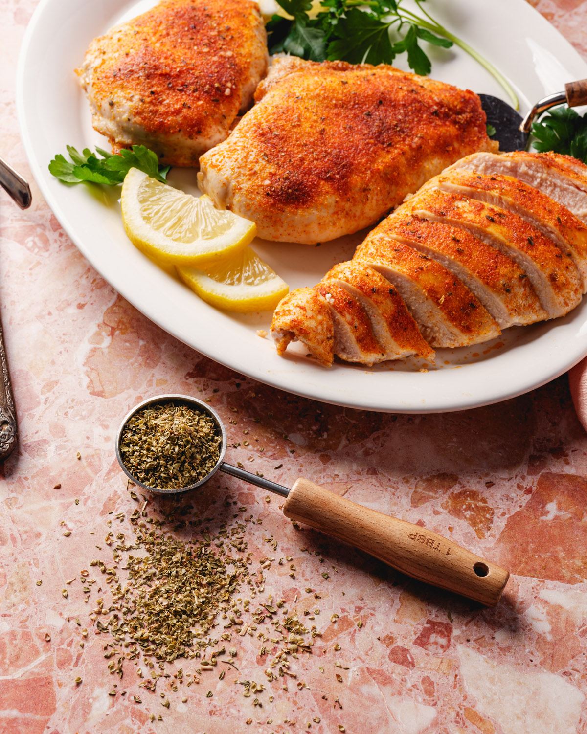 Oven baked chicken recipe on platter with dried oregano
