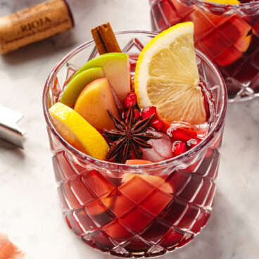 Thanksgiving Sangria in glass with fruit and spice garnish