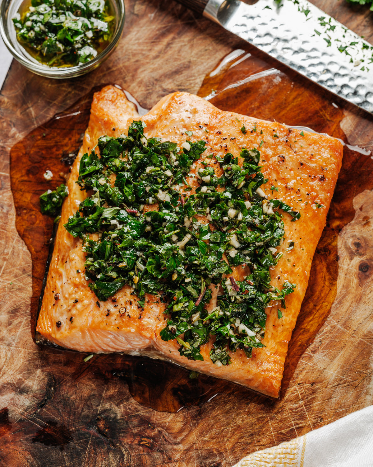 Salmon with chimichurri sauce on cutting board