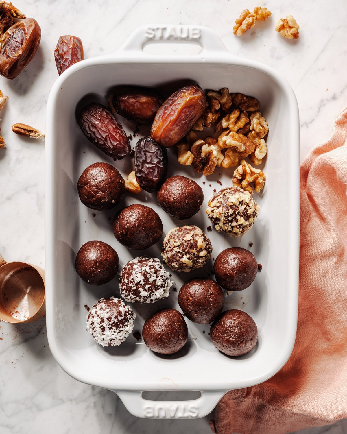 Peanut butter energy balls in baking dish with dates and walnuts